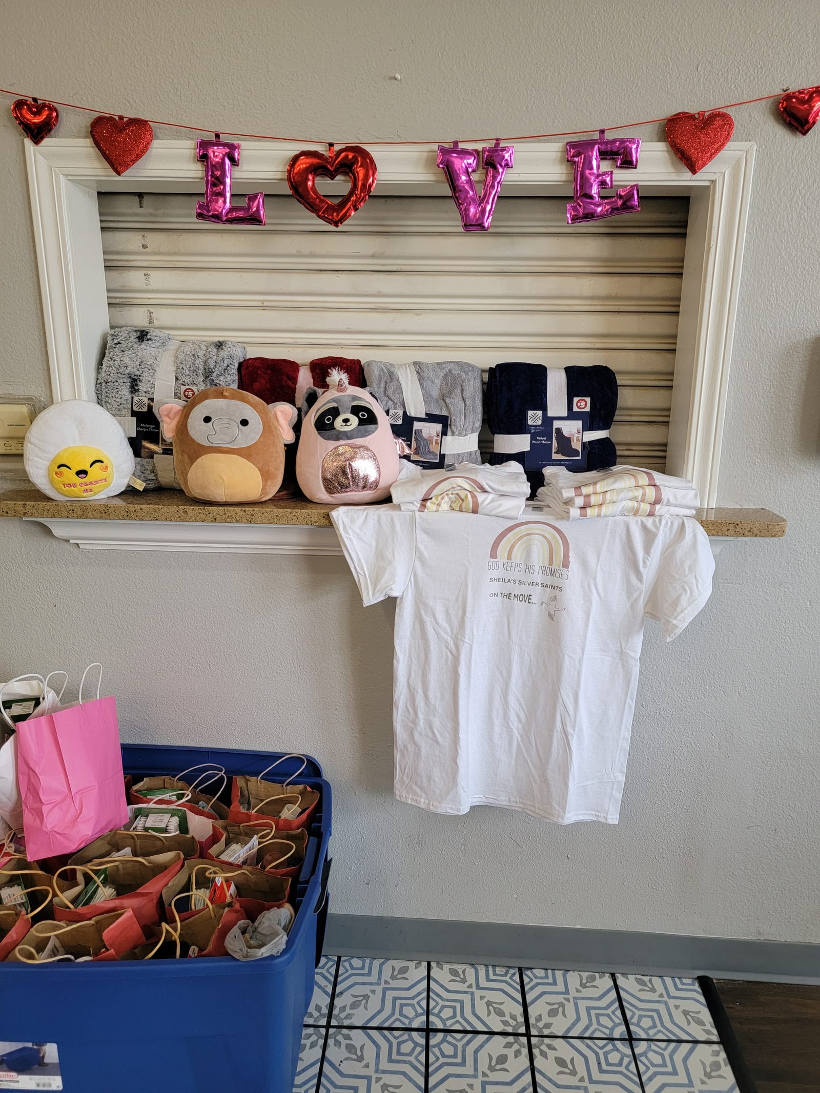 Prize table with a Love banner, plush toys and Silver Saints shirts